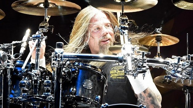 Chris Adler Lamb of God Departure and Estranged Family Ties Chris Adler performing live on drums with long hair flowing, surrounded by cymbals and drum hardware.