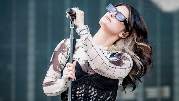 Spiritbox Wembley Stadium Show with Linkin Park Marks a Career Milestone Spiritbox frontwoman Courtney LaPlante performing live on stage, wearing sunglasses and holding a microphone.