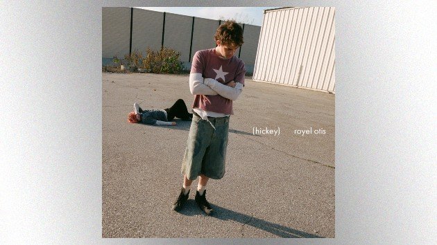 Royel Otis Releases New Track “Car” from Upcoming Hickey Album Cover art for Royel Otis’s album “Hickey,” featuring two band members in an empty lot—one standing with arms crossed, the other lying on the ground in the background.