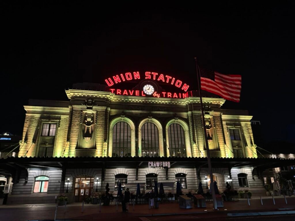 Denver Union Station illuminated at night with American flag in front, LoDo district, Denver Colorado