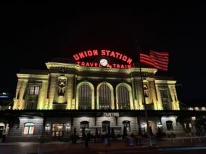 Denver Union Station illuminated at night with American flag in front, LoDo district, Denver Colorado