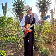 Jen Korte performing as Lady Gang, playing electric guitar outdoors in Denver, Colorado