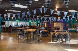 Inside the Bootstrap Brewing taproom in Longmont, Colorado with tables, flags, and customers enjoying craft beer