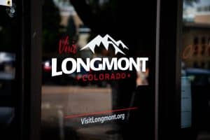 Visit Longmont Colorado tourism logo on storefront window