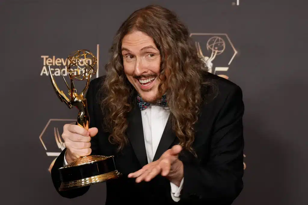 Weird Al Yankovic smiling while holding an Emmy Award at the Television Academy