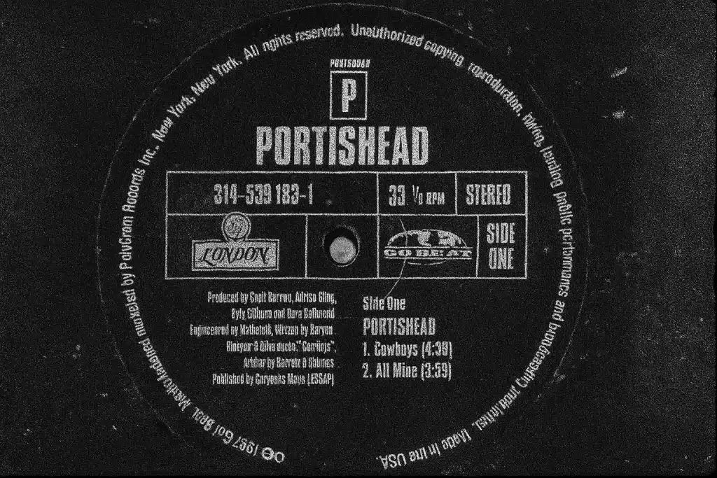 Black-and-white close-up of the Portishead self-titled album vinyl label featuring the Go! Beat and London Records logos, Side One track listing, and production credits.