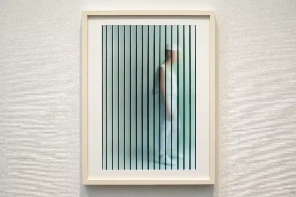 Framed conceptual artwork featuring a side profile of the Neon the Bishop character in a white outfit seen through vertical optical illusion lines