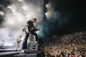 Djo performing live on stage during a high-energy concert